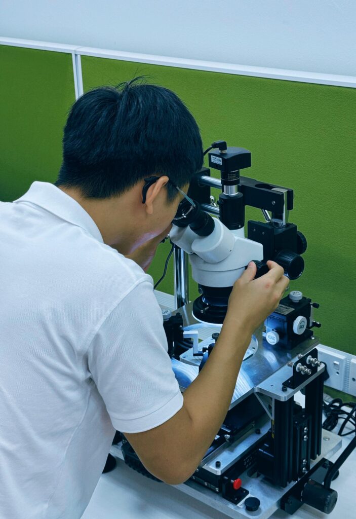 Student using microscope in engineering lab - Infinecs